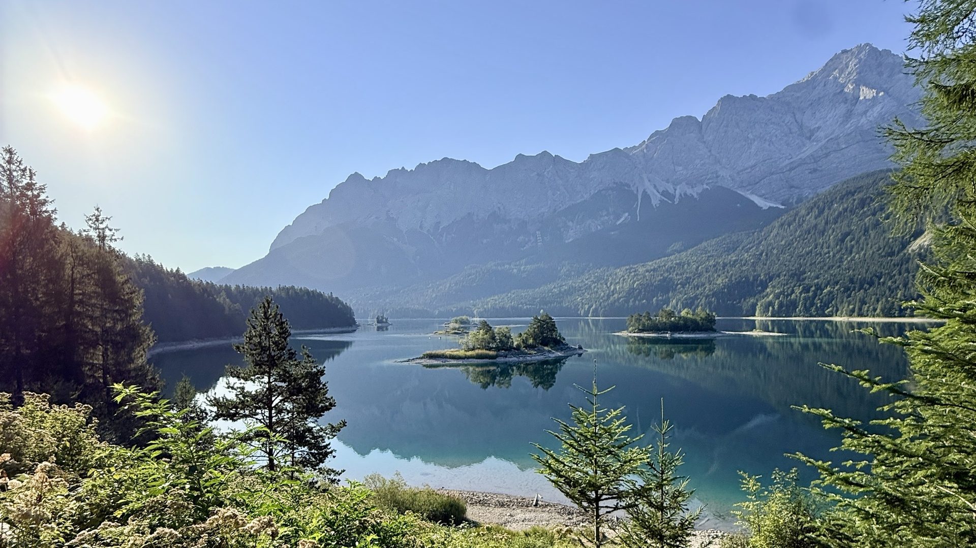 Der Eibsee mit kleinen Inseln, dahinter das Zugspitzmassiv